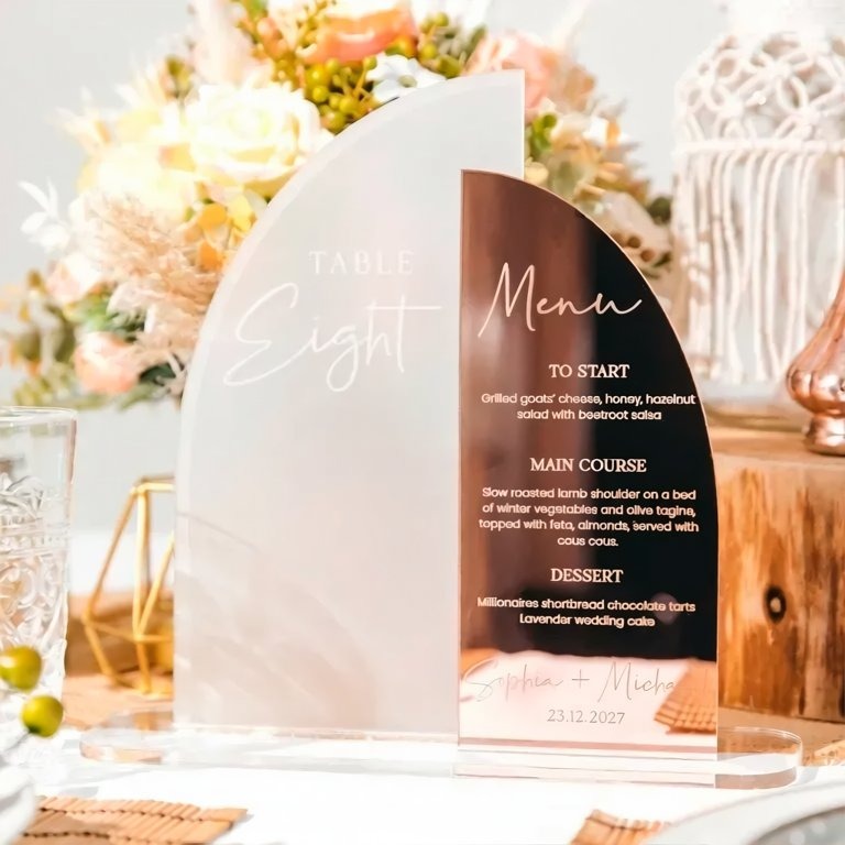 a table setting with a clear glass menu stand displaying a menu for a meal.