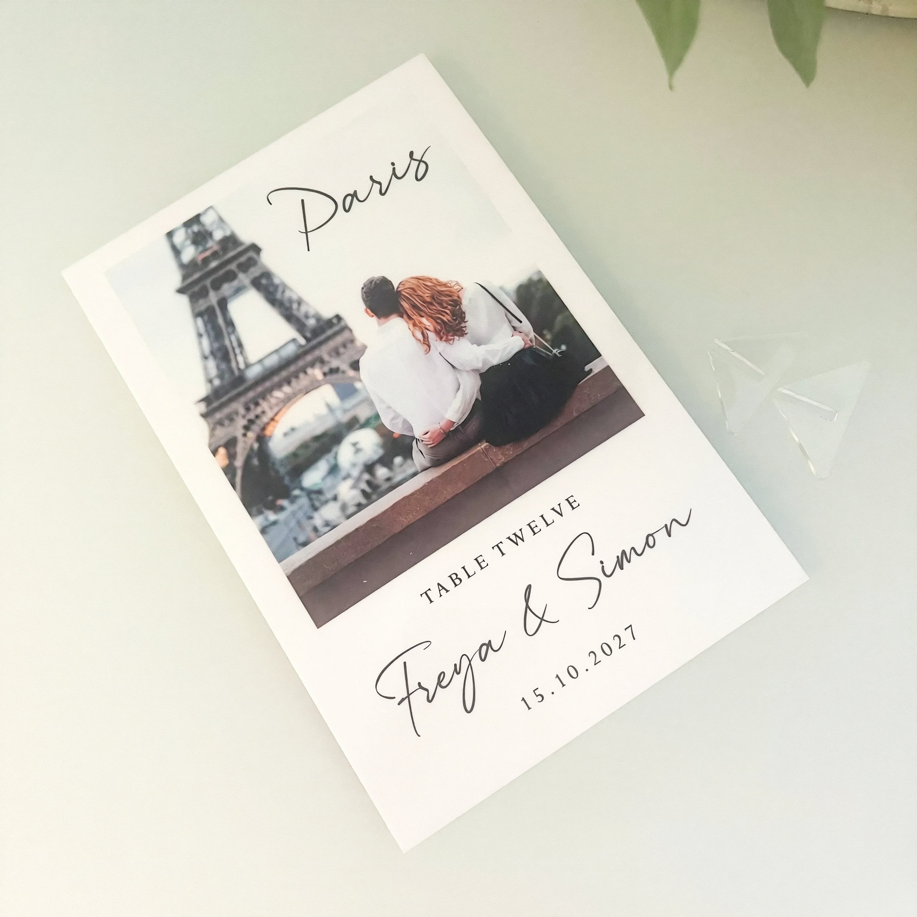 The image is a wedding invitation card featuring a couple sitting on a bench in front of the Eiffel Tower, with the text "Paris" and "Table Twelve" printed on it.