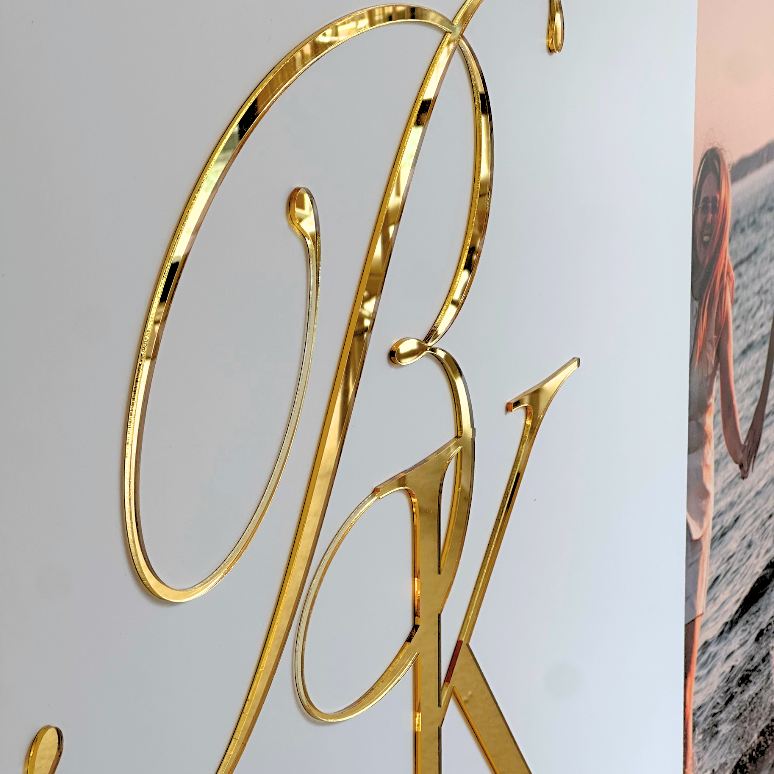 a close-up view of a golden letter "P" and "K" on a white background.