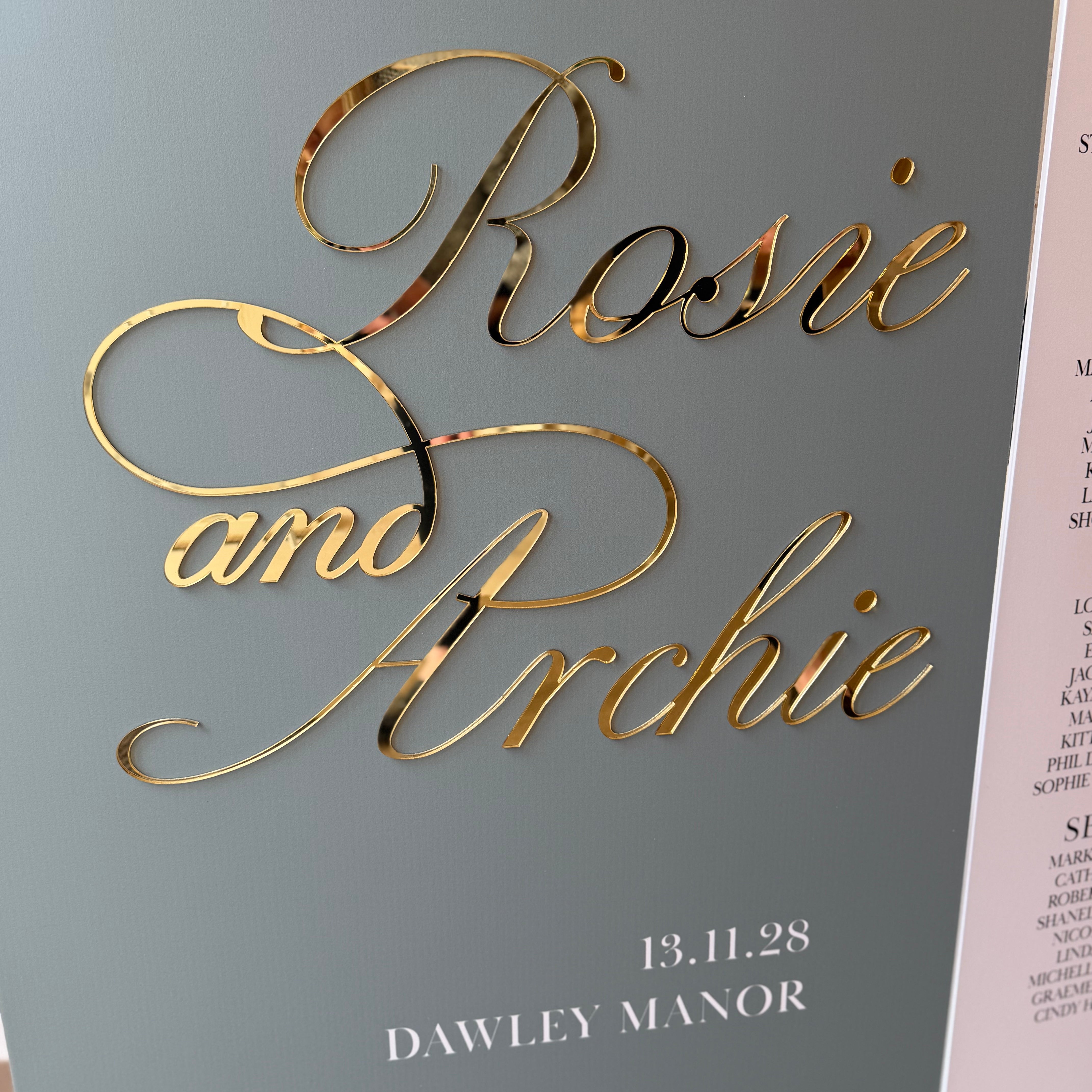 a grey background with gold text that reads "Rosa and Archie" and "13.11.28" below it.