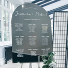 A wedding seating plan sign for the wedding of Jasmine and Michael, with details of the tables and their assigned guests.