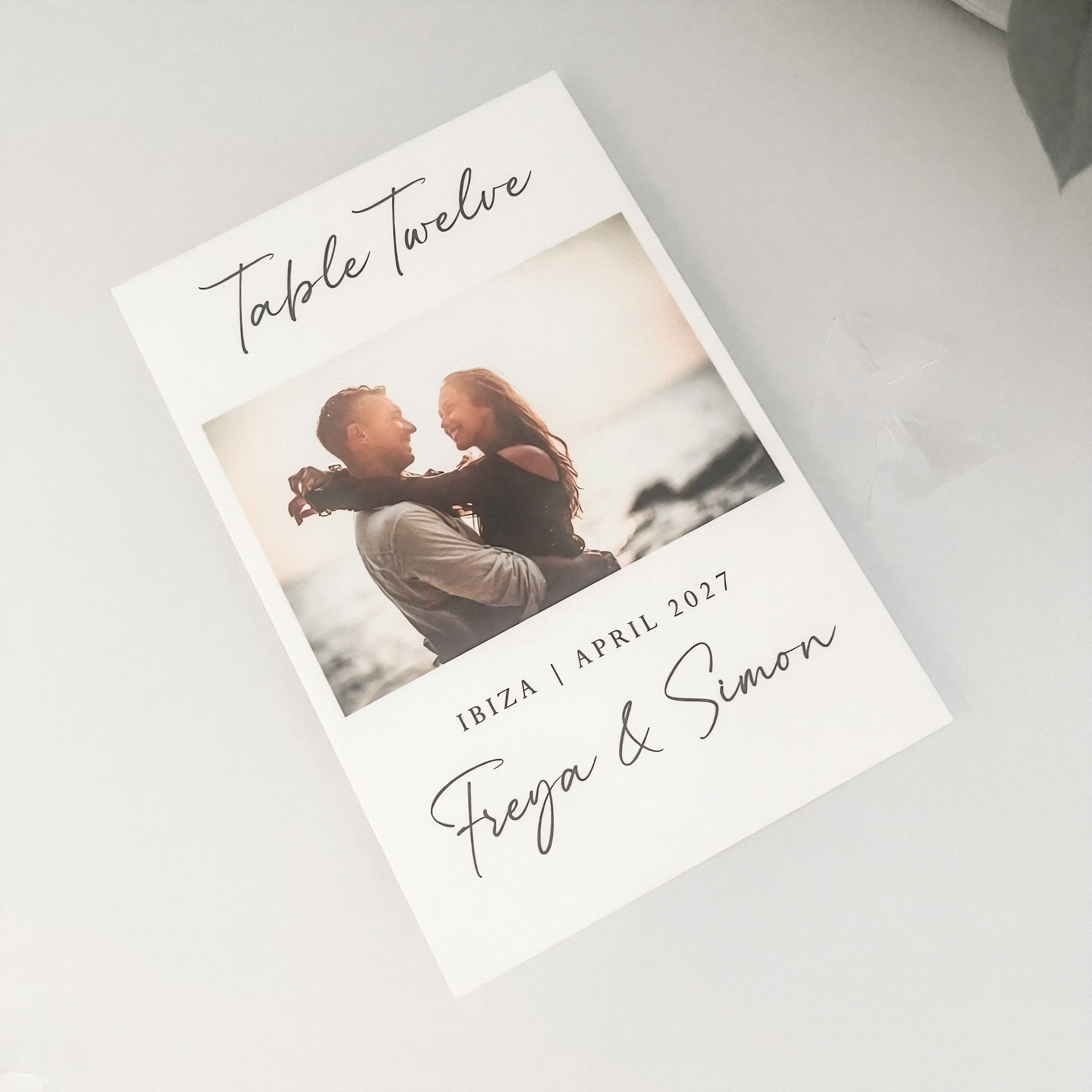 The image is a wedding invitation card featuring a couple embracing in a romantic photograph.