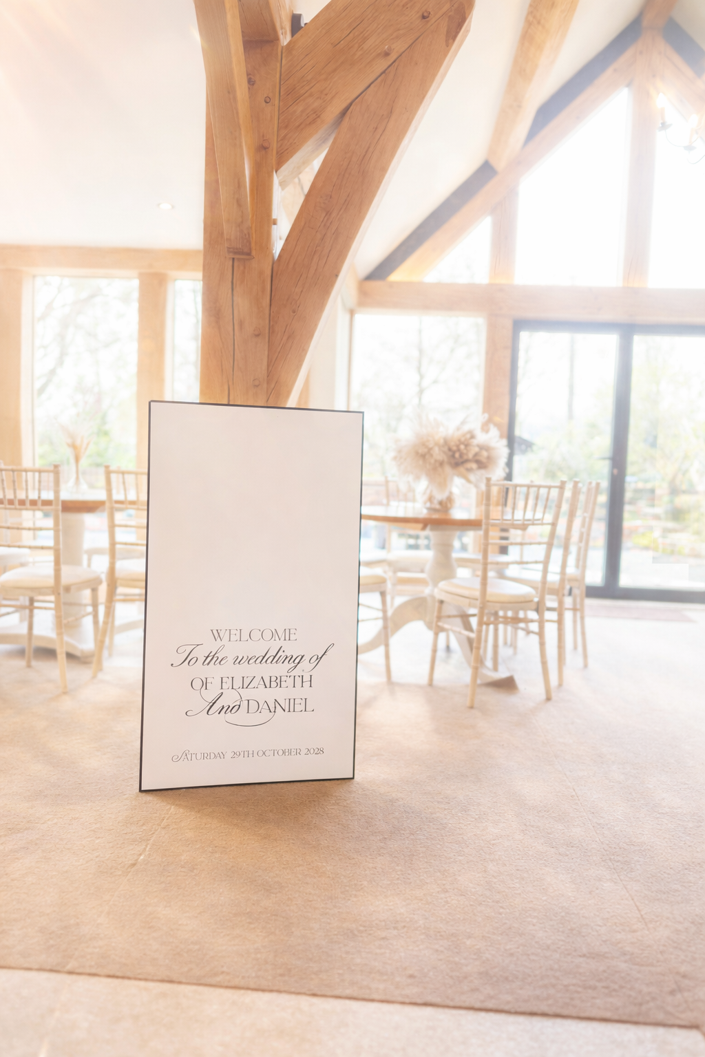 a wedding reception setting with a sign welcoming guests to the wedding of Elizabeth and Daniel.
