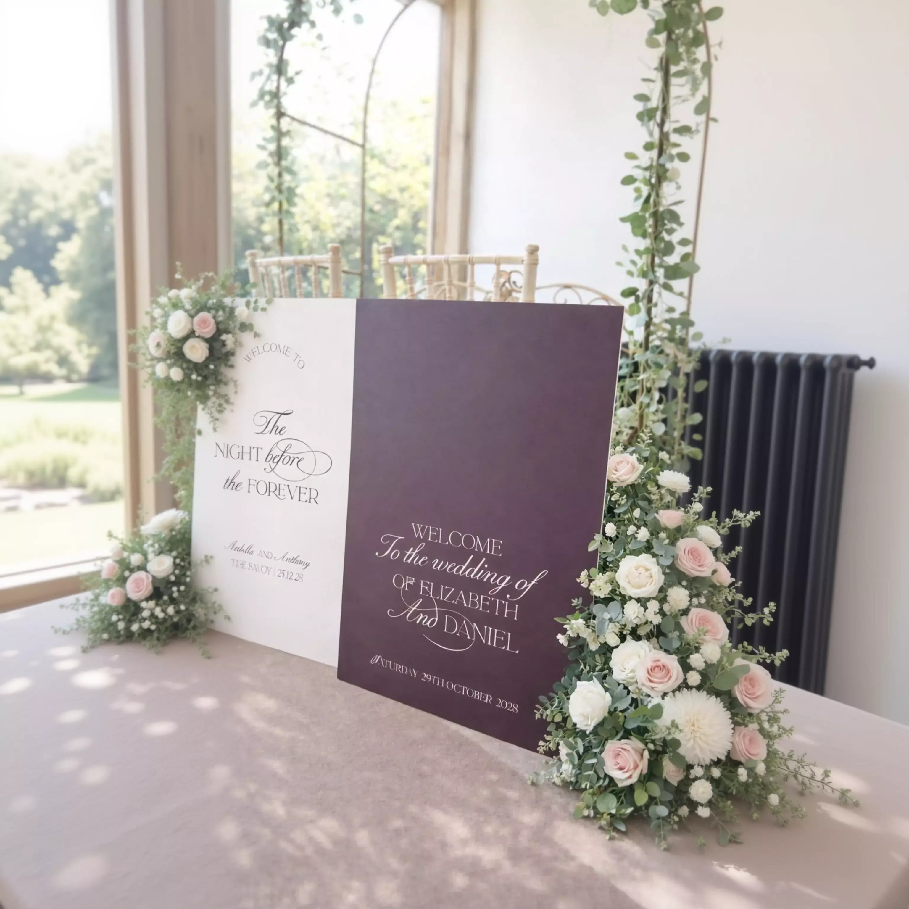 a wedding ceremony setup with two large signs welcoming guests to the wedding of Elizabeth and Daniel. The signs are adorned with white and purple flowers, and the text on the signs reads "Welcome To The Wedding Of Elizabeth And Daniel".