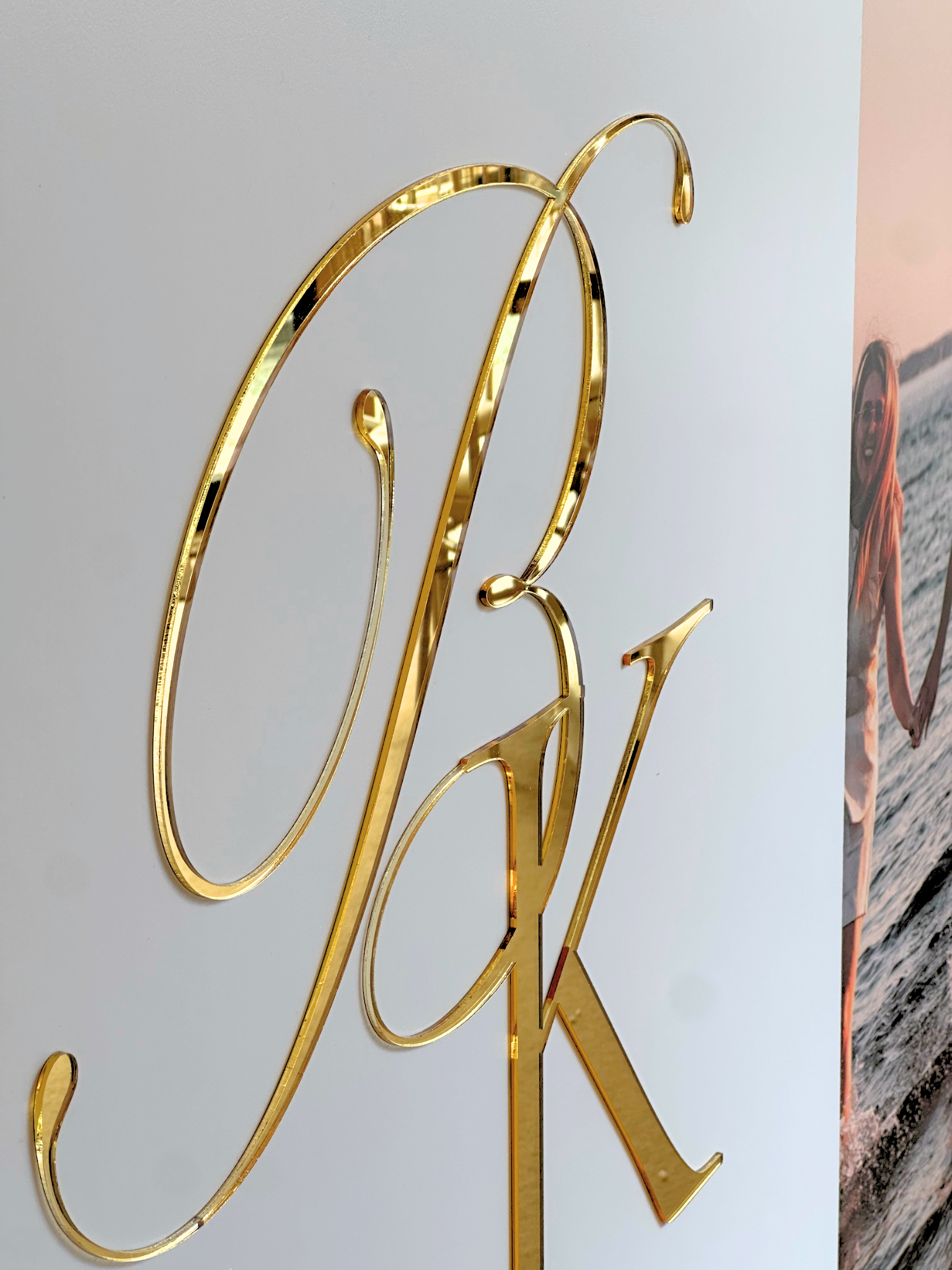 a close-up view of a golden letter "P" and "K" on a white background.