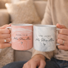 A couple holding matching mugs with the text " Soon to be Mrs Hamilton" and "One lucky Mr Hamilton" printed on them.