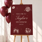 A red sign welcoming guests to Taylor's Hen Weekend, with balloons and a disco ball in the background.