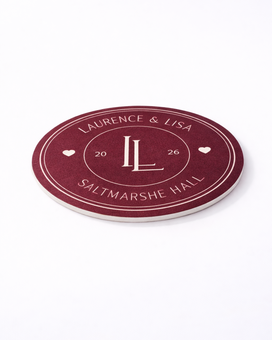 A maroon coaster with the text "Laurence & Lisa" and "SALTMARSHE HALL" printed on it.
