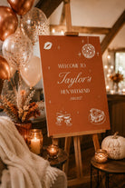 a red sign welcoming guests to Taylor's Hen Weekend, with a festive atmosphere created by the presence of balloons, candles, and other decorations.