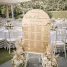 a wedding reception seating plan displayed on a wooden sign.