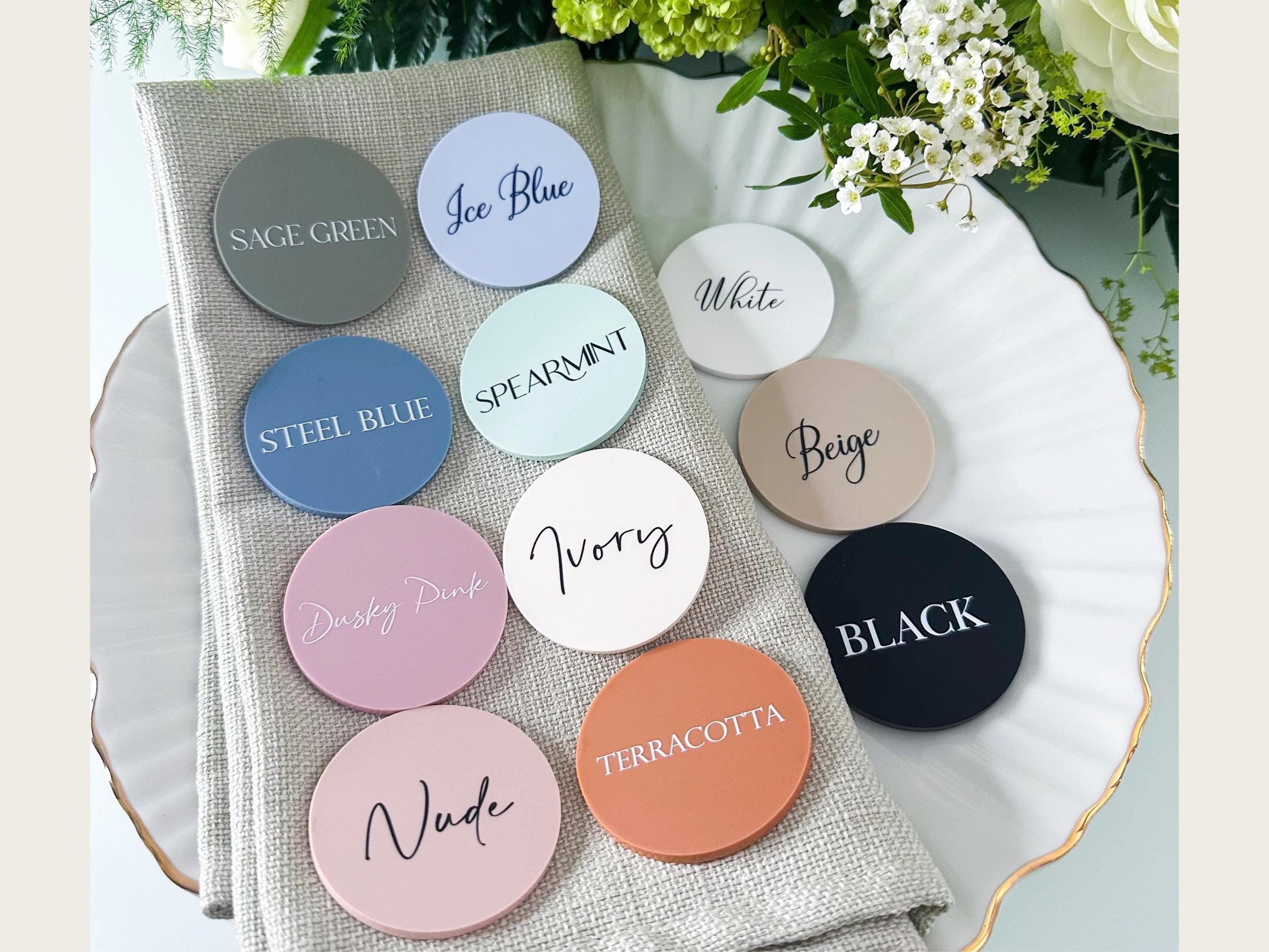 A collection of colorful coasters or stickers with text on them, placed on a white plate or napkin.