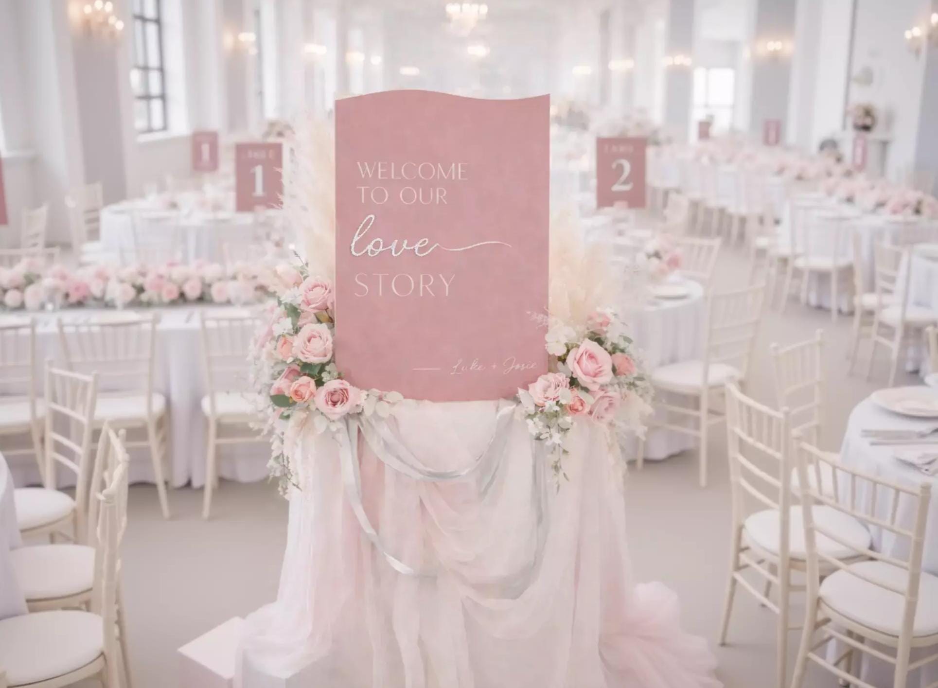 a pink sign with the text "Welcome to our love story" and a signature " Luke & Jane" on it, surrounded by pink flowers and a pink tablecloth.